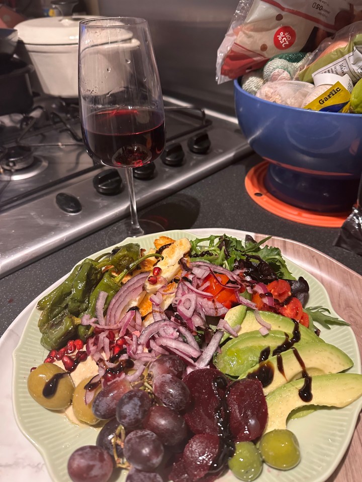 a plate of food on a table next to a glass of wine