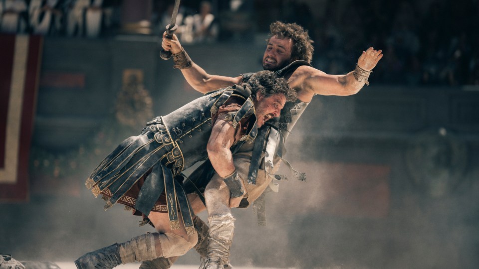 a man in a greek key outfit is carrying another man on his back