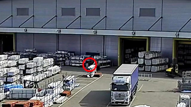 a white truck is parked in front of a large warehouse .