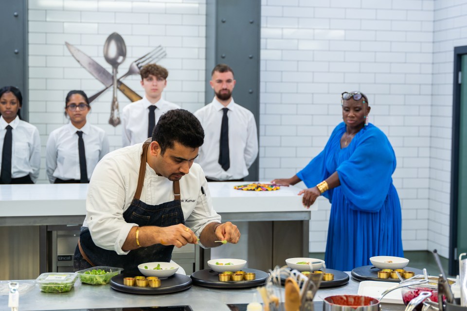 a man in a chef 's apron prepares food in a kitchen