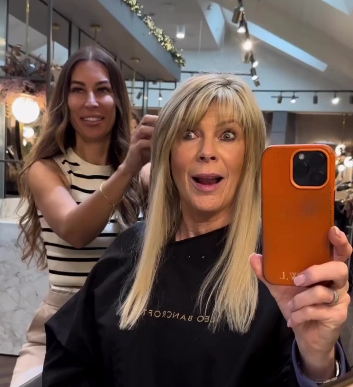 a woman taking a picture of herself with a phone that says j.w. on it