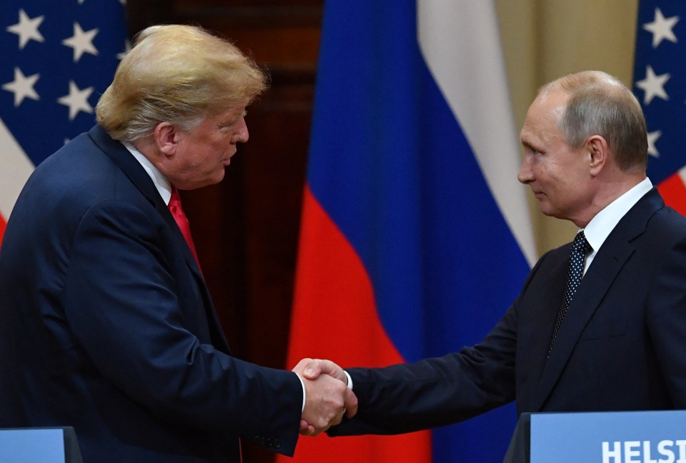 two men shake hands in front of flags and a sign that says helsi