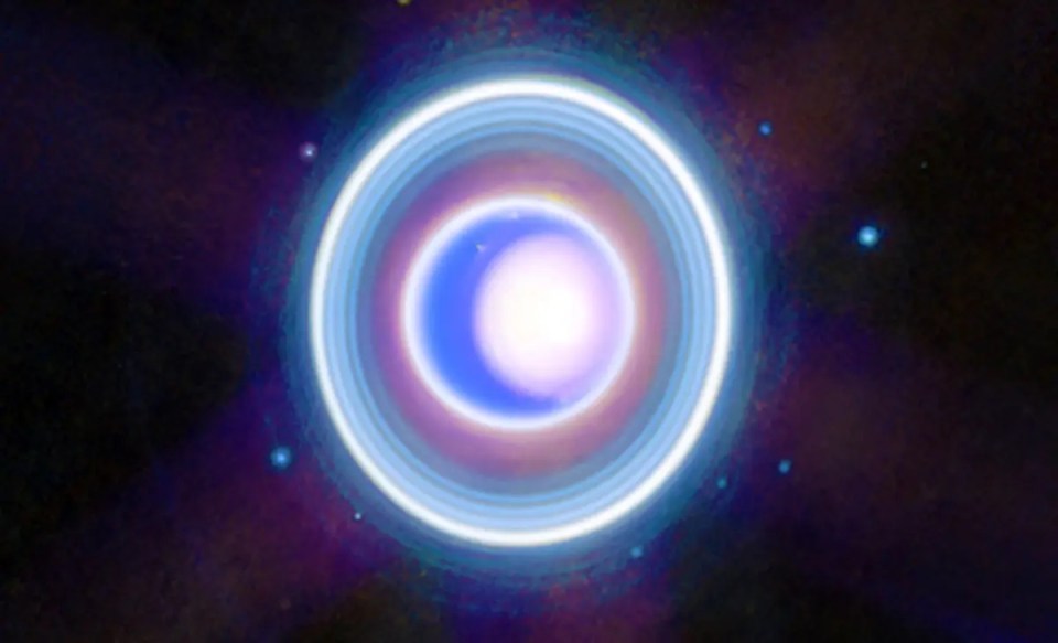 a purple and blue circle in the middle of a dark space