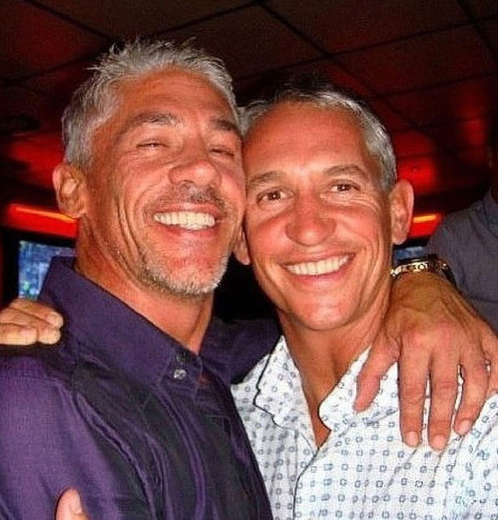 two men are hugging each other and smiling for the camera .
