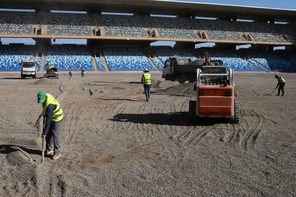 Construction workers preparing a stadium field for the 2025 African Cup of Nations.