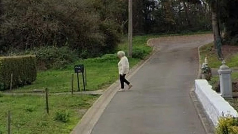 Woman walking down a residential street.