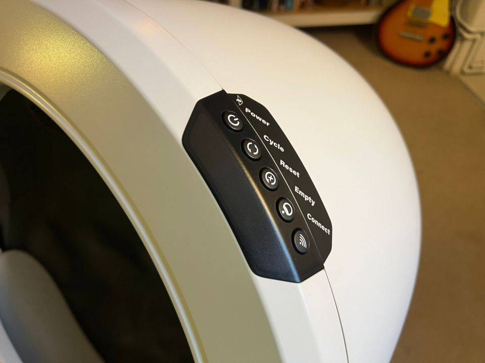 Close-up of a device's control panel with buttons for power, cycle, reset, empty, and connect.