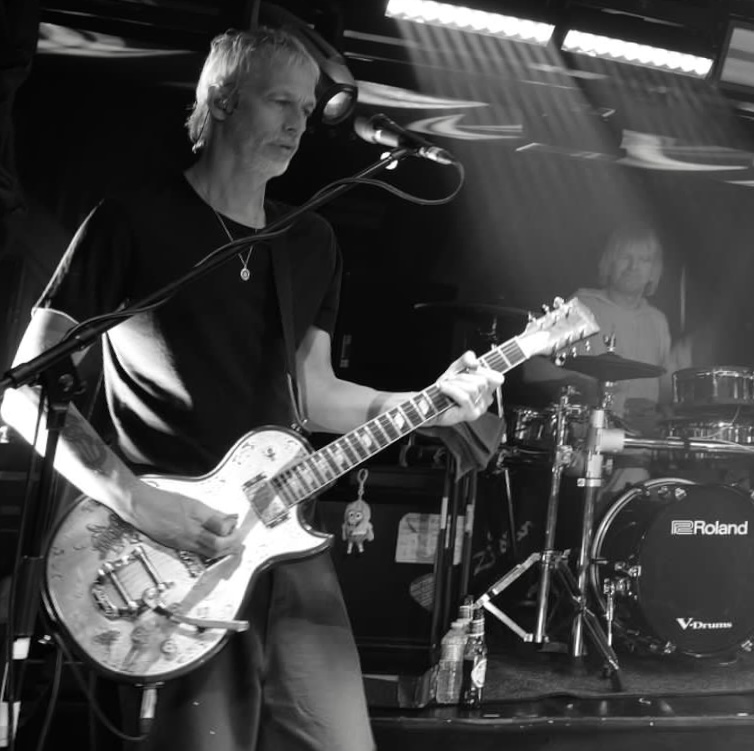 Lawrence Watson playing guitar on stage.