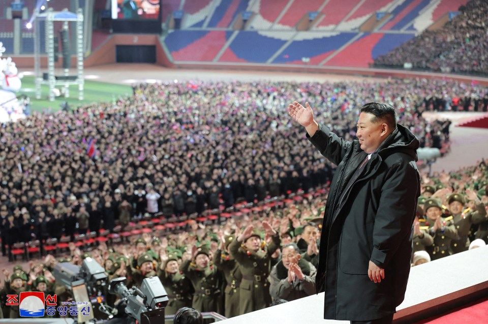 Kim Jong Un waving to a large crowd at a New Year's performance in Pyongyang.