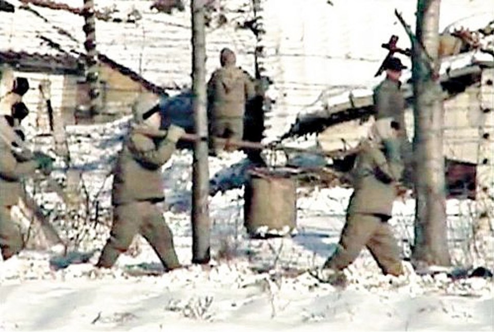 Prisoners carrying heavy objects at Yodok concentration camp.