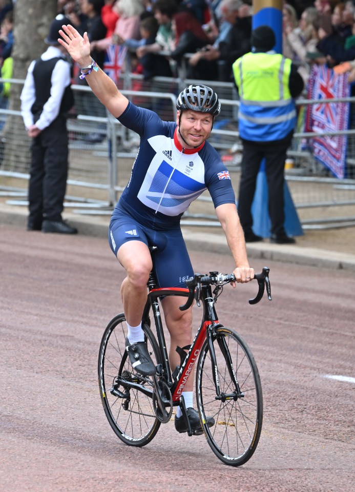 Sir Chris Hoy waves while cycling in the Platinum Jubilee Pageant.
