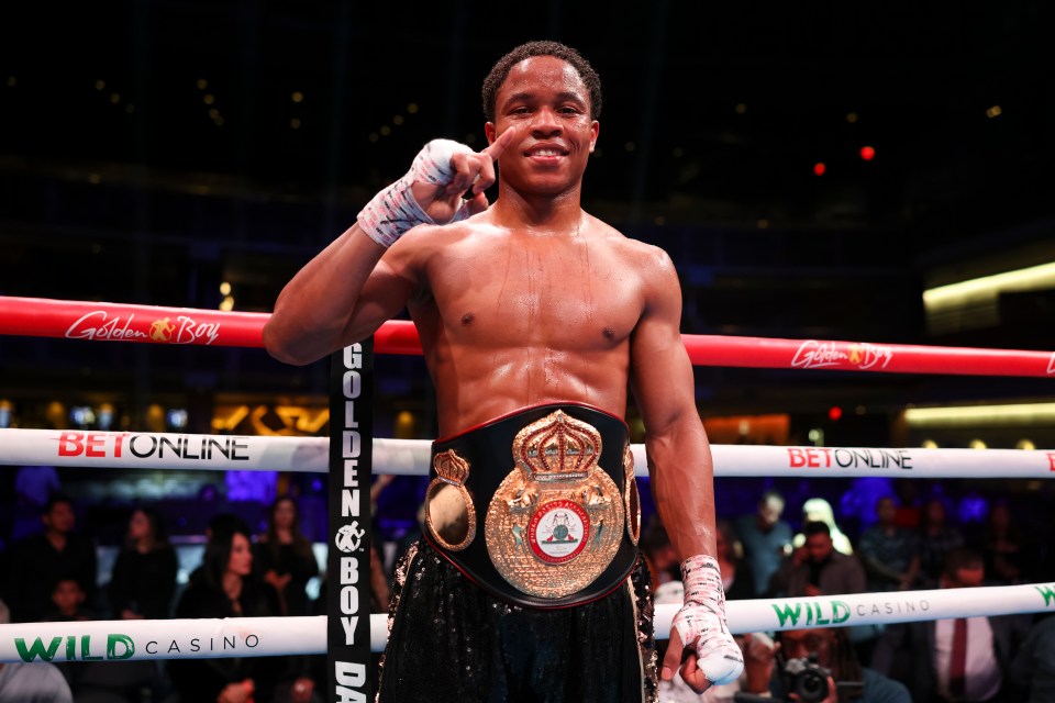 Floyd Schofield victorious in a boxing match, holding a championship belt.