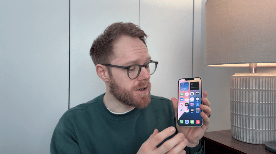 Man holding up an iPhone.