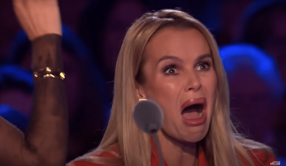 Woman with shocked expression at microphone.