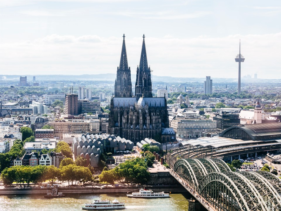 Aerial view of Cologne, Germany, showing the Cologne Cathedral, Hohenzollern Bridge, and Rhine River.