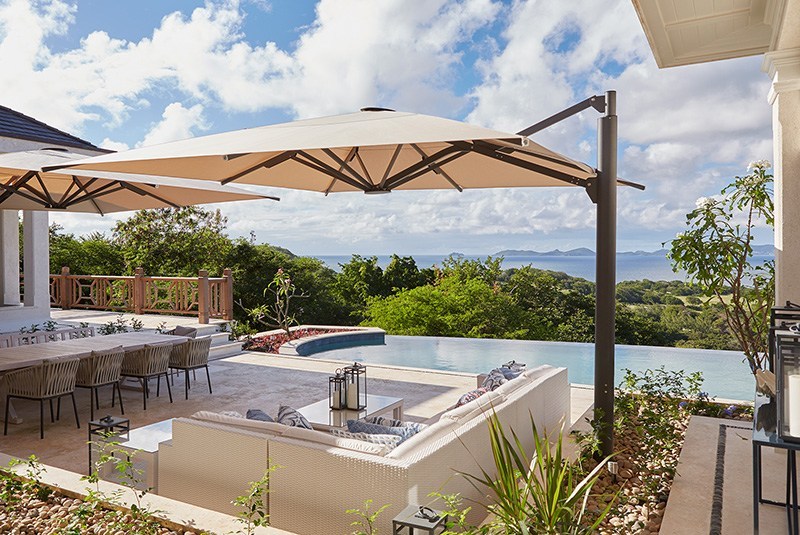 Luxury villa patio with infinity pool and ocean view.