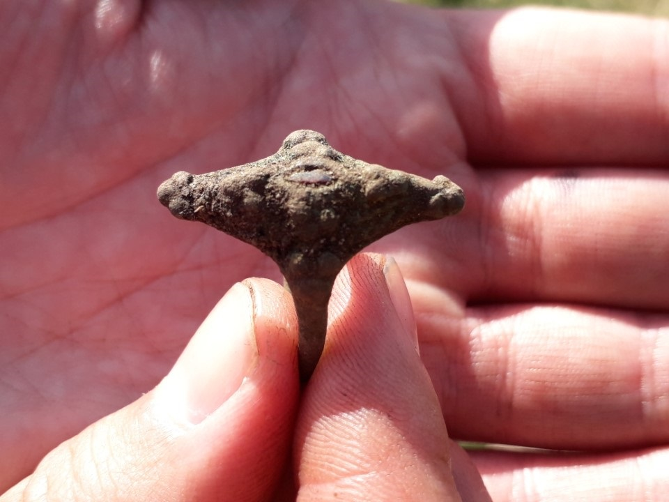 Close-up of a Pictish ring held in a hand.