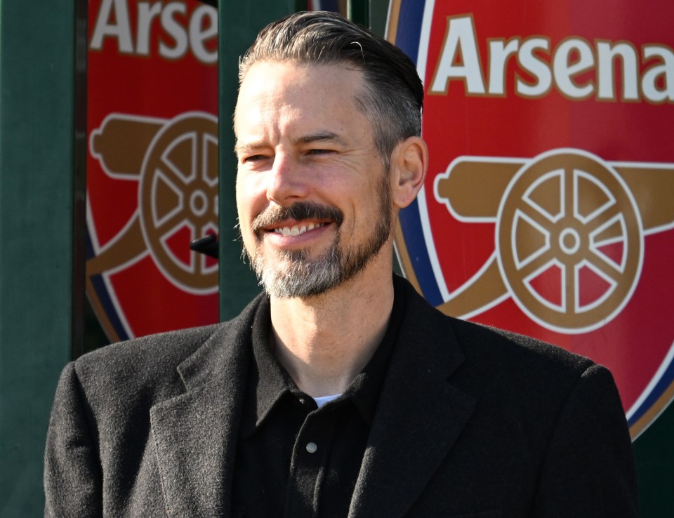 Josh Kroenke, Arsenal director, holding a coffee cup.