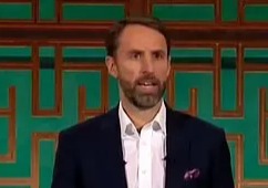 Man in suit speaking at a podium.