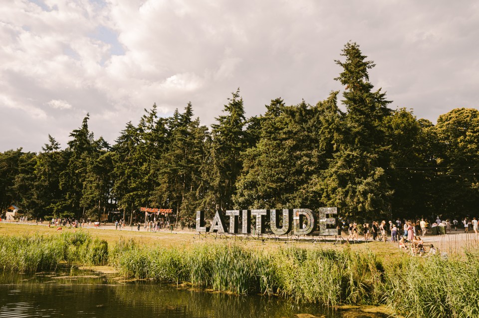 Latitude festival sign in front of trees and a pond.