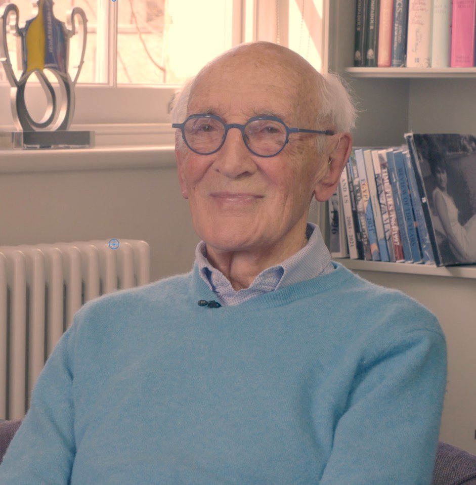 Portrait of an elderly man in a light blue sweater.
