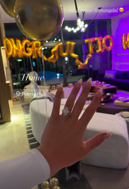Engagement ring displayed with "Congratulations" balloons in the background.