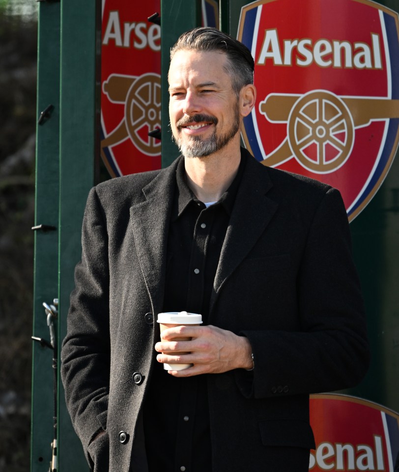 Josh Kroenke, Arsenal director, holding a coffee cup.