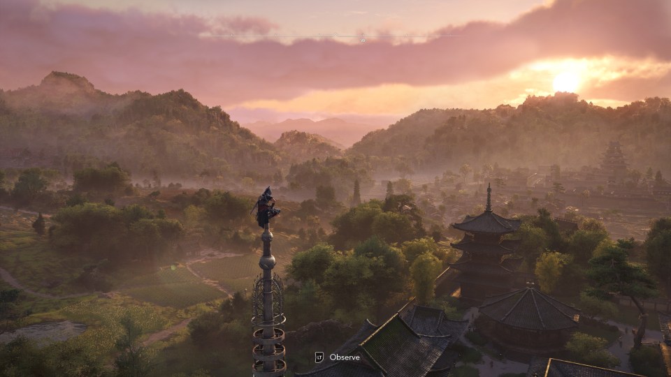 Assassin's Creed Shadows: a figure perched atop a pagoda overlooking a sun-drenched Asian village.