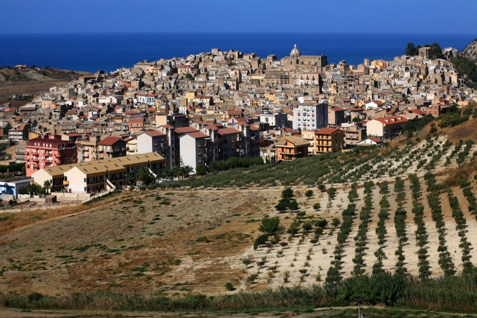 Siculiana, Sicily, Italy, viewed from above, showing the town's architecture and surrounding olive groves.
