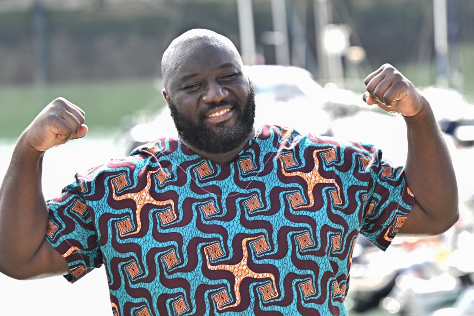 Bruce Dombolo flexing his biceps at a photocall.