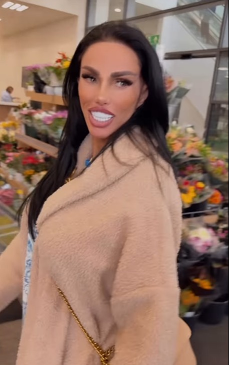 Woman in a pink coat in a flower shop.