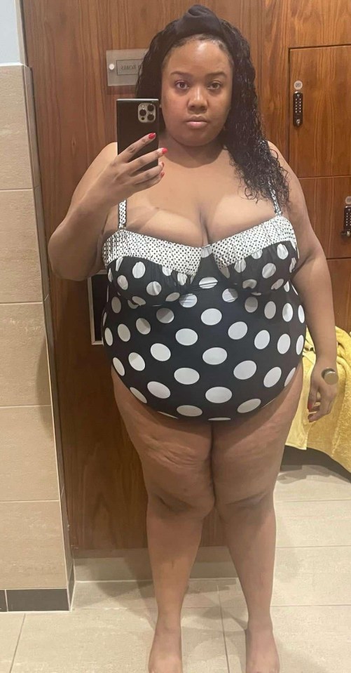 Woman in a black and white polka dot swimsuit taking a selfie.