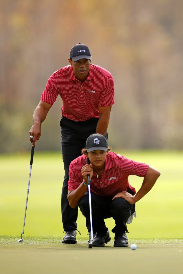 Tiger Woods watches his son Charlie Woods putt on the green.