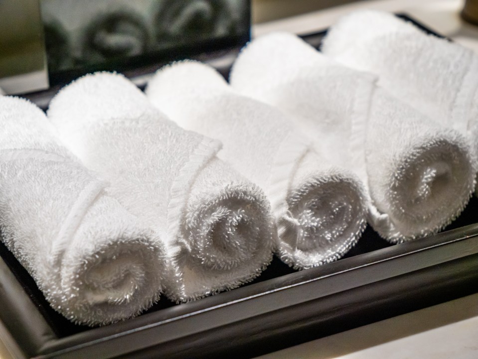 Rolled-up white towels on a tray.