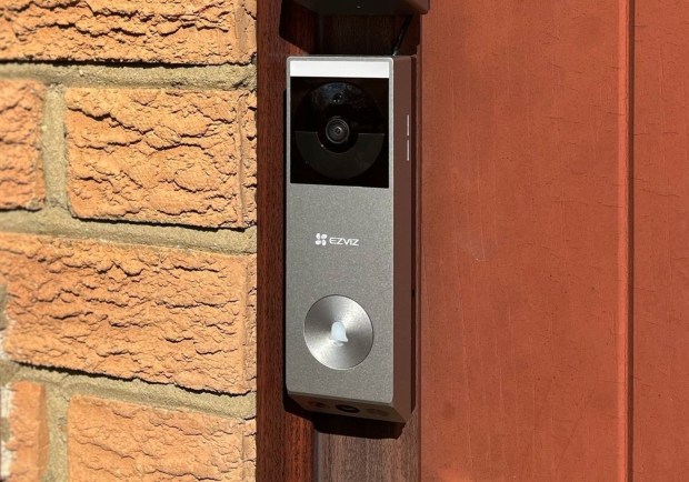 EZVIZ video doorbell mounted on brick wall.