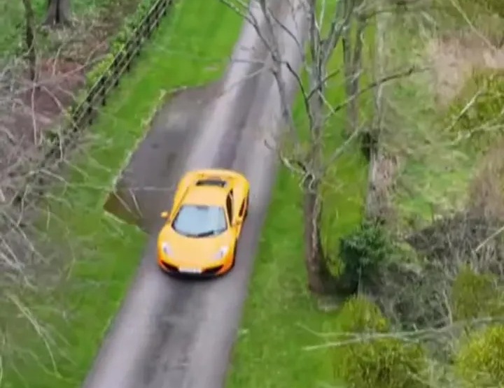 Yellow McLaren on a country road.