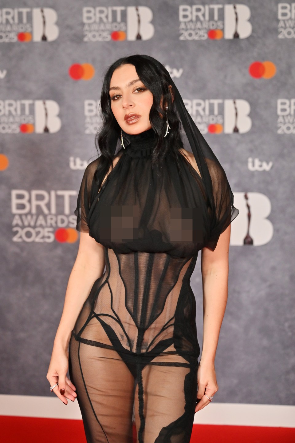 Charli XCX at the BRIT Awards 2025 in a sheer black dress.