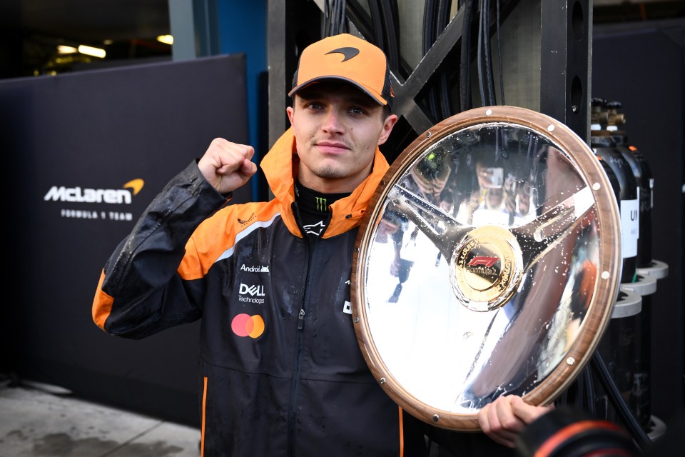 Lando Norris of McLaren celebrates with a Formula 1 trophy.