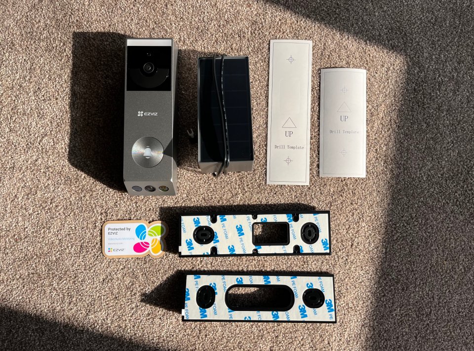 EZVIZ doorbell camera with accessories and installation template.