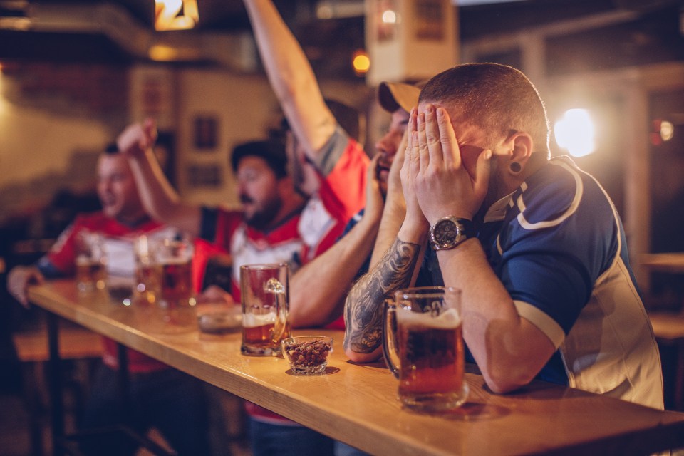 Sad group of men watching game in sports pub