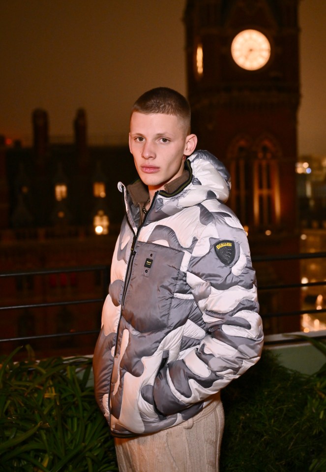 Freddy Brazier at a Blauer fashion event, wearing a gray and white camouflage puffer jacket.