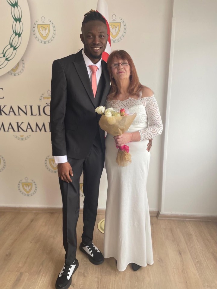 A bride and groom pose for a wedding photo.