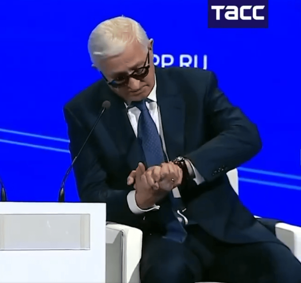 Man in suit checking his watch.