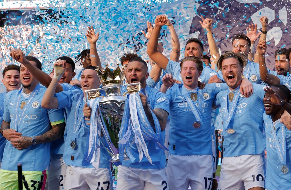 Erling Haaland of Manchester City shaking hands with mascots at a trophy ceremony.