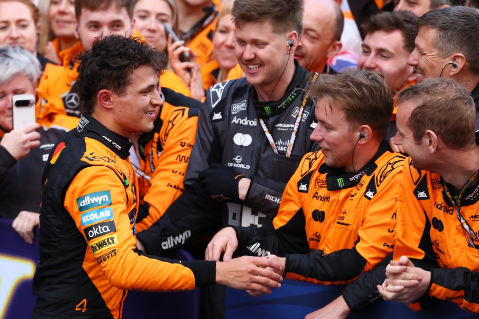 Lando Norris celebrating with his team after winning a race.