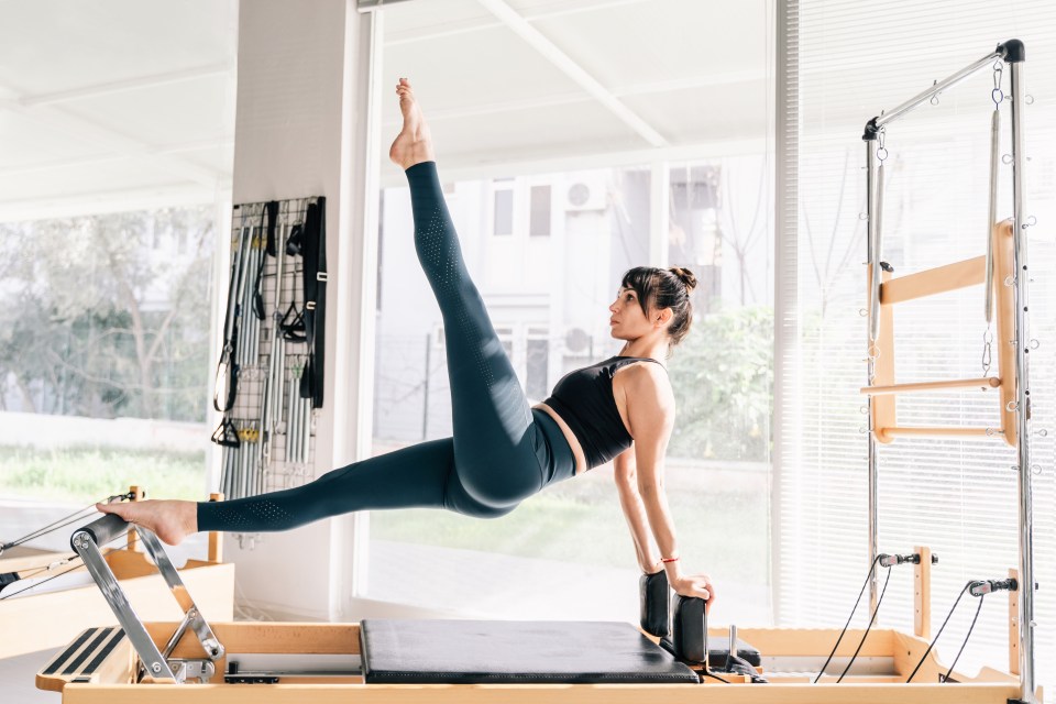 Woman doing Pilates on a reformer.