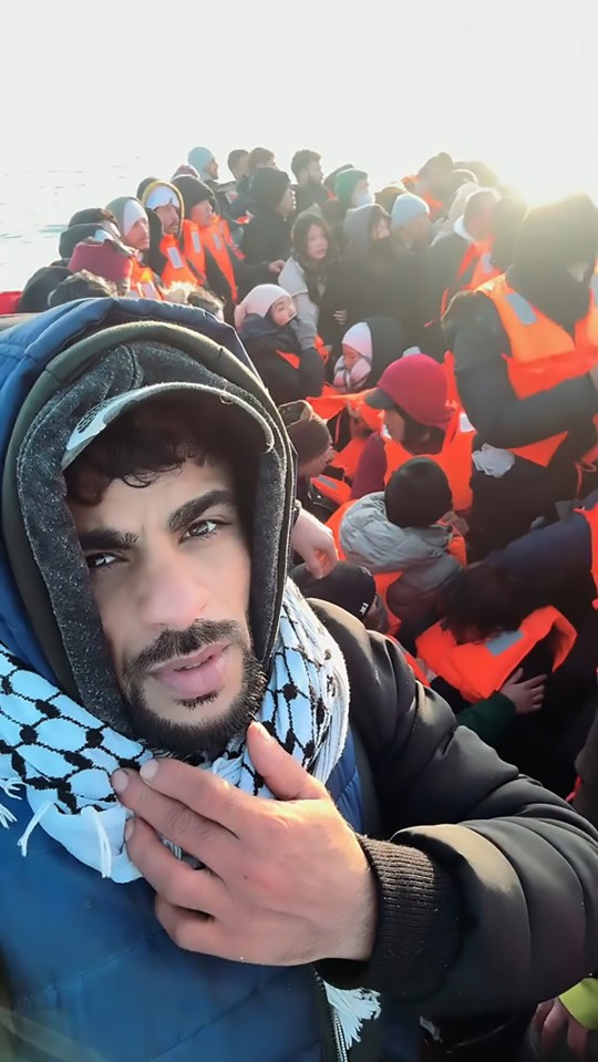 A man in a crowded migrant boat makes a selfie.