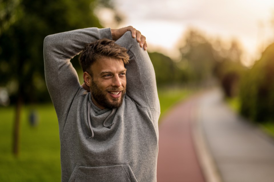 Man stretching outdoors before a workout.