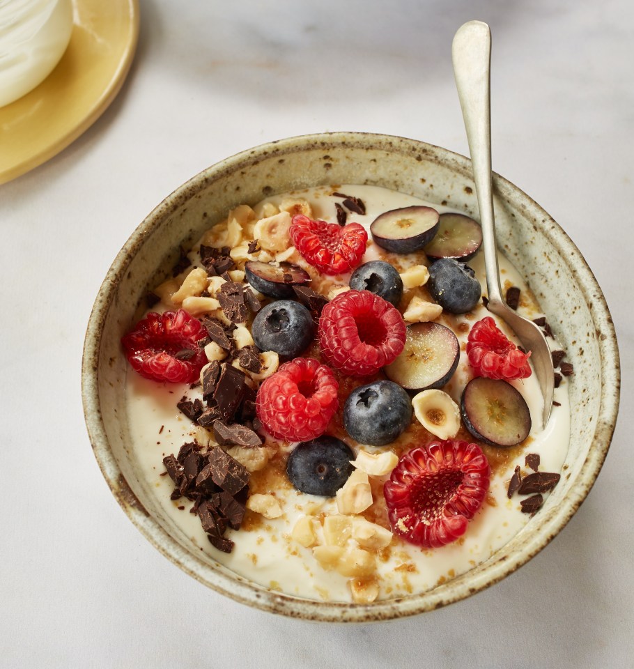 Yogurt parfait with raspberries, blueberries, hazelnuts, and chocolate.