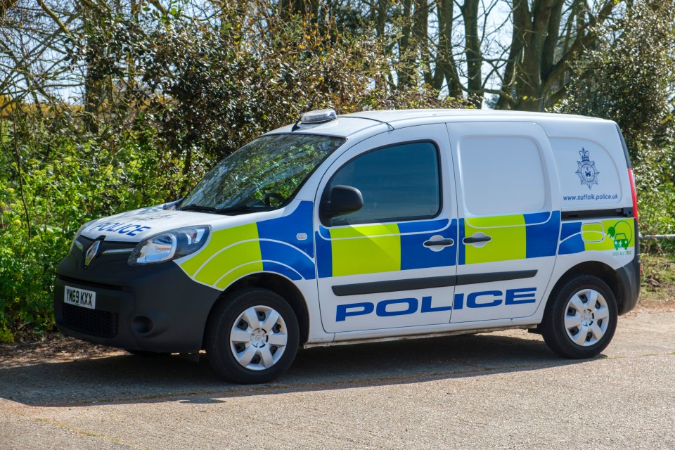 A police van parked near a beach.